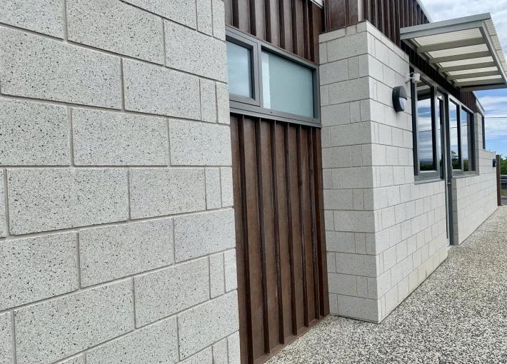 white block wall with a timber section in the middle