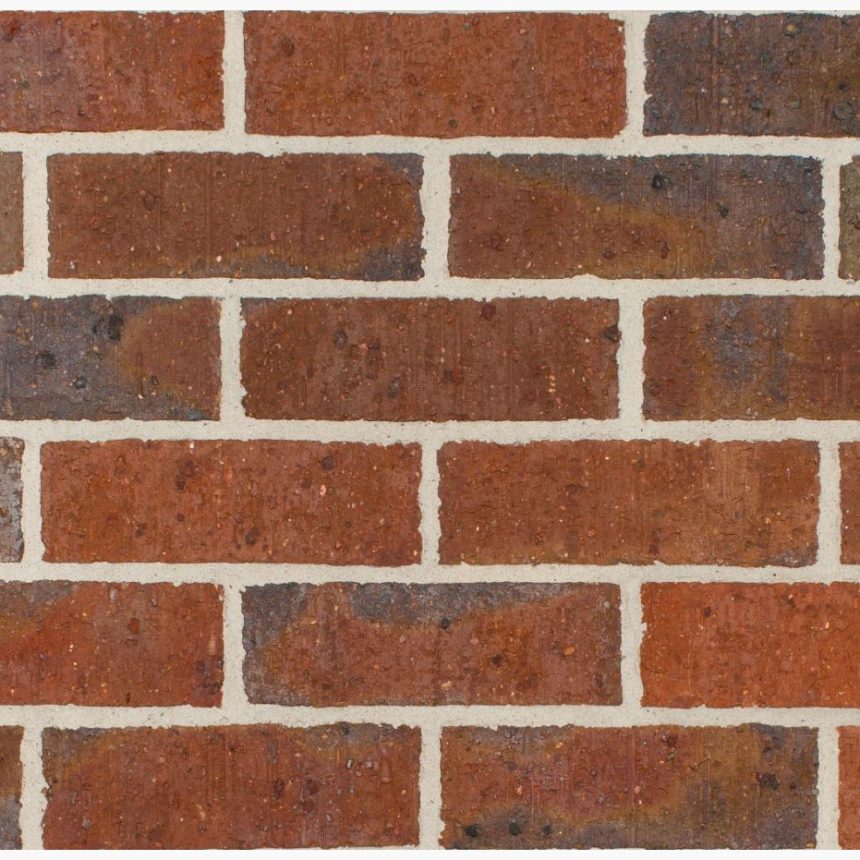 A close-up view of a red brick wall highlights subtle color and texture variations, as traces of the Hawthorn 76 Tan product gently peek through the mortar, creating a classic and sturdy appearance.