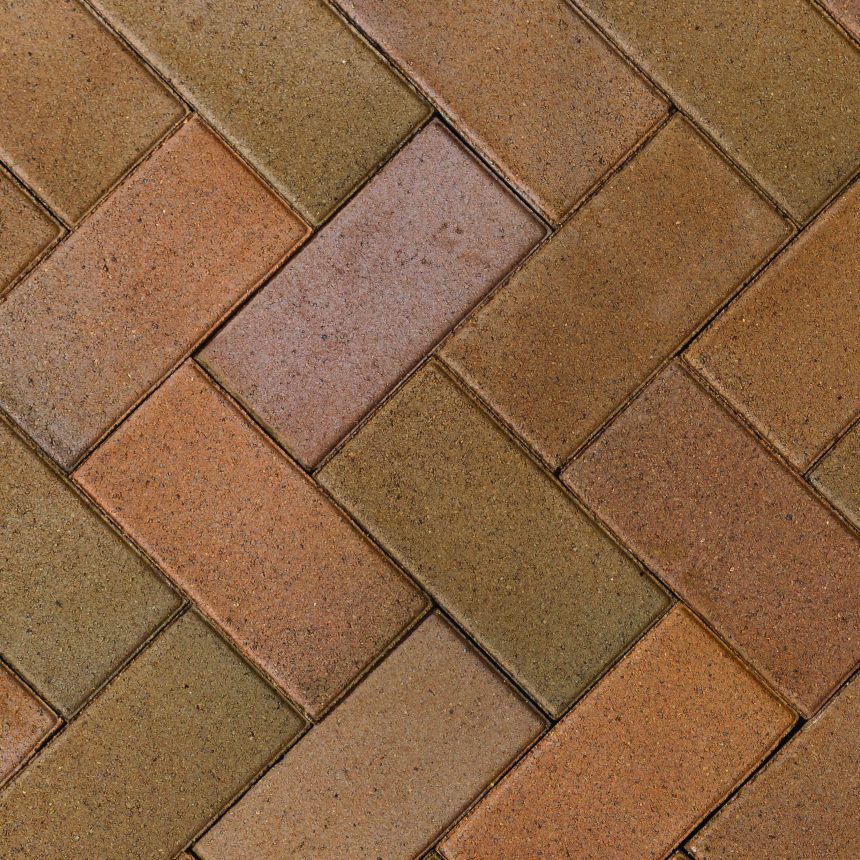 Close-up of a brick pavement displaying a herringbone pattern, with shades of brown and tan highlighting the London Chestnut. The reddish-brown tones create a textured and interlocking design.