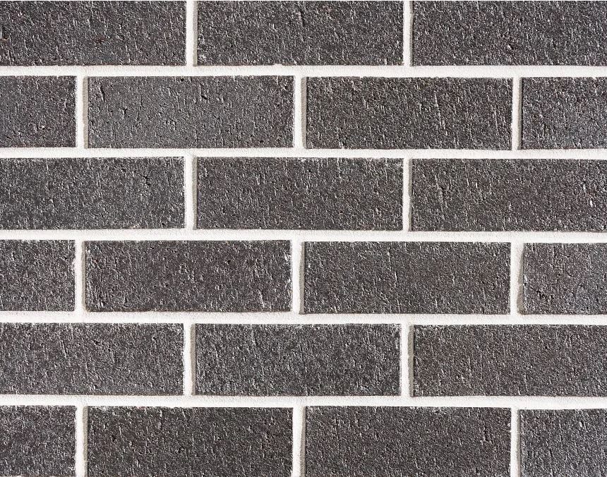 A close-up of a gray brick wall with evenly arranged rectangular bricks and white mortar between them, creating a uniform and structured pattern akin to the style of Metallix Quartz.