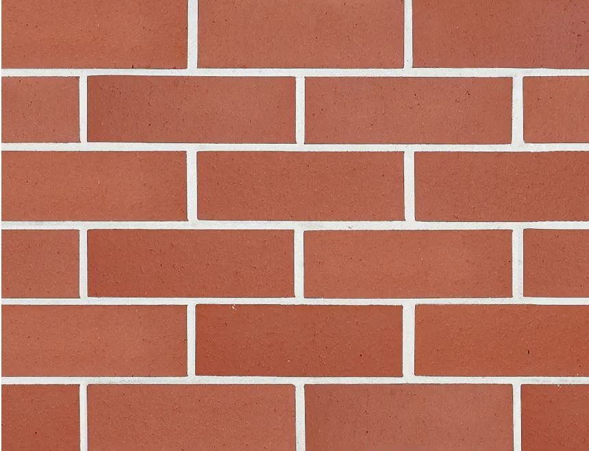 The Symmetry Terracotta bricks create a neatly arranged wall with four horizontal rows. Each brick is uniformly sized and separated by white mortar lines, resulting in a consistent pattern and perfect symmetry across the surface.