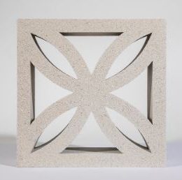 The Breeze Block Solid Grey features a decorative floral pattern with four intersecting petal-like shapes that create a symmetrical design. This square block, in its calming light grey color, stands gracefully against a plain background.