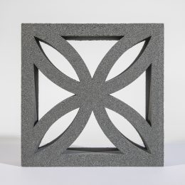 The Breeze Block Lotus Grey showcases a geometric design with four curved, pointed shapes arranged symmetrically within a square frame. Its textured surface creates a subtle shadow on the light background, enhancing its elegant appearance.