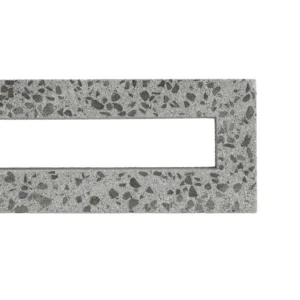 A rectangular piece of speckled grey concrete, the GB Breeze Blocks linear Nickel, features a central rectangular cut-out. Pictured on a white background, only the object’s top left corner is visible in the image.