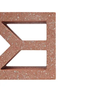 A close-up of the GB Breeze Blocks Diamond Pottery in red-brown shows its geometric cut-out design, inspired by pottery. Set against a white background, only part of the block appears on the left, highlighting its unique style.