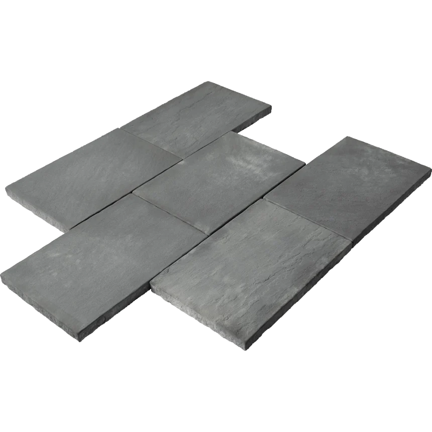 A set of six Centurystone 600 Storm Pavers, rectangular and grey, are laid out in a staggered pattern against a white backdrop. Their rough texture and subtly varied shades create a natural and rugged look.