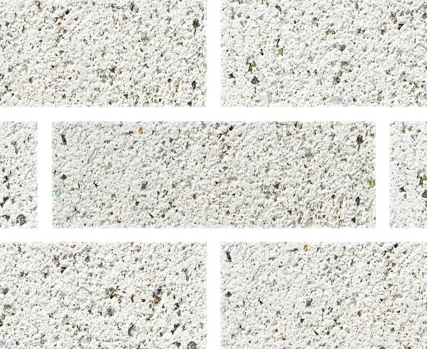 An Exposed Pearl ECO wall features a textured white brick surface with visible mortar lines and a rough finish. Each brick includes small speckles of gray and black, creating a subtle speckled pattern throughout the wall.
