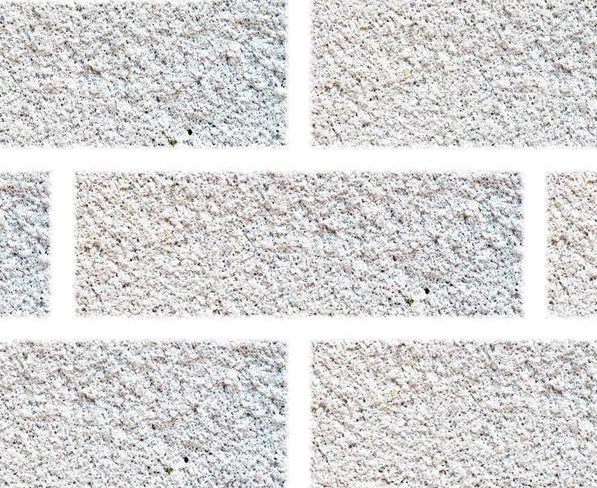 Close-up of an Exposed Pure White textured brick wall. The bricks are arranged in a typical staggered pattern with visible roughness and speckles, creating a rustic appearance. The mortar between the bricks is also white, blending with the overall color.