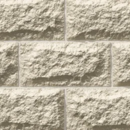 A close-up of a GB Sandstone Rockface Limestone wall shows rough, light beige rectangular stones in a staggered layout with thin mortar joints.