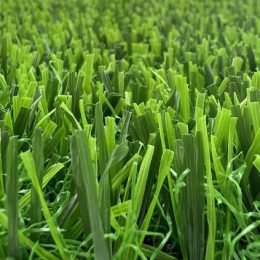 Close-up of artificial grass with bright green blades standing upright.
