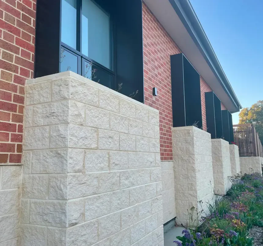 Littlehampton Bricks and Pavers Light Cabernet Bricks in a wall on a house with long black windows and cream coloured blocks below the windows