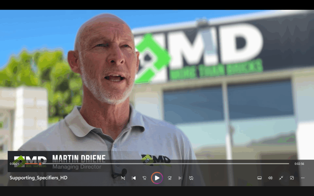 A man with a white beard speaks outside a building featuring an MD logo and the words More Than Bricks, highlighting Architectural Designer Products. Video controls and the text Martin Driene, Managing Director appear at the bottom.