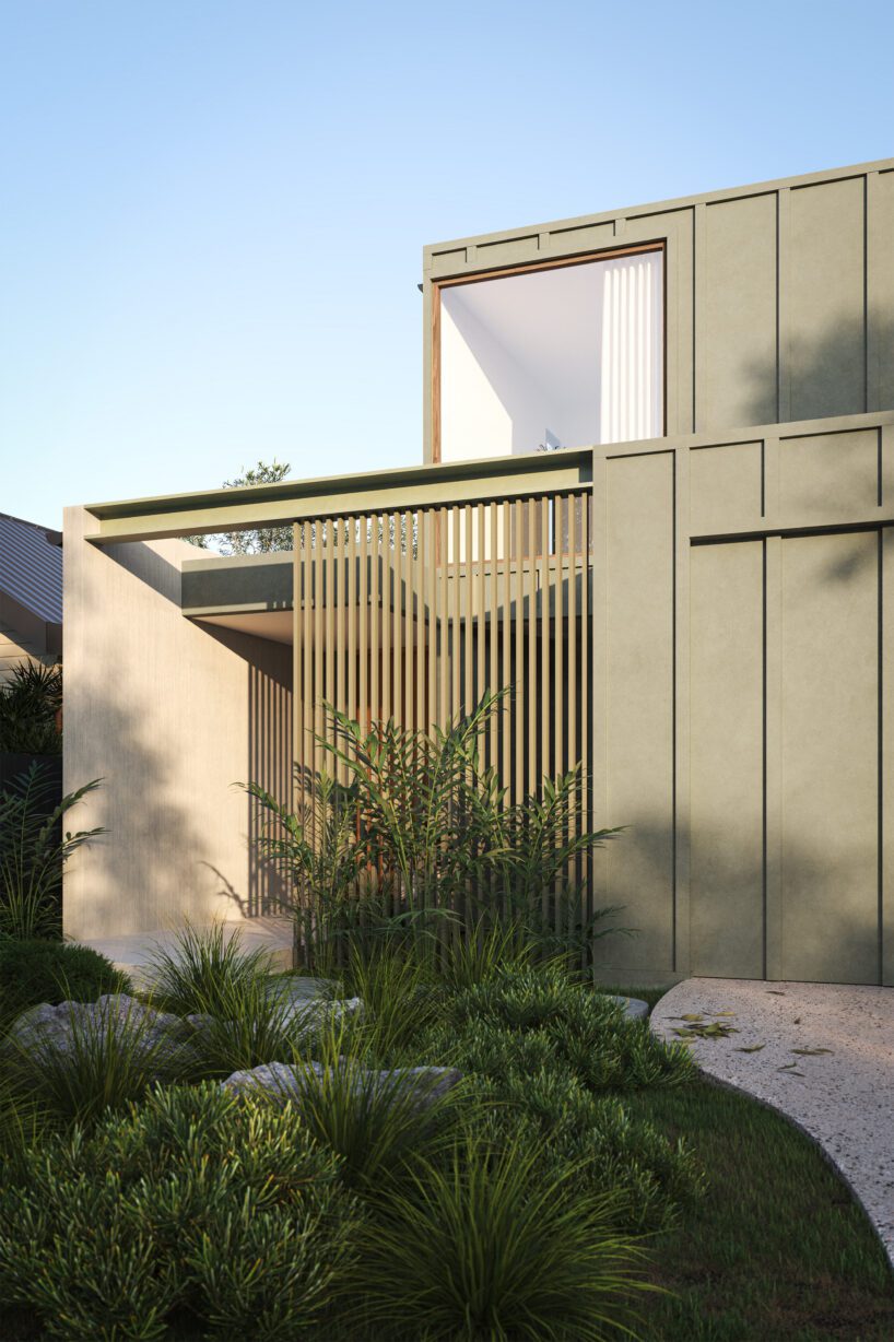 Modern two-story house with greenish Innova Fibre Cement exterior walls, vertical slats for shade, large windows, and minimalist landscaping with grass and shrubs under a clear blue sky.