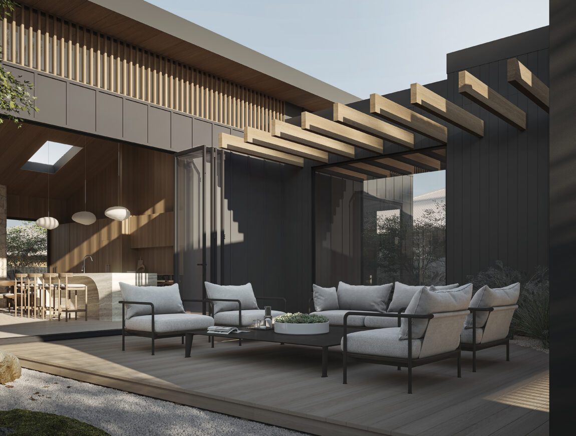 Modern outdoor patio with cushioned seating and a round coffee table on an Innova Fibre Cement deck. Large glass doors open to a stylish dining area with pendant lights and wooden accents as sunlight filters through an overhead pergola.